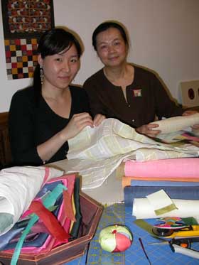 Master artist Bonghwa Kim (right) and apprentice Yejin Cha working on a chogak-po at Casa Muhyang in Los Angeles.