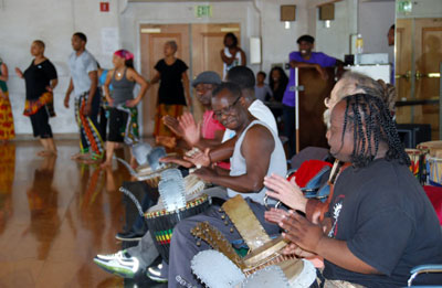 The drumming core features Dr. Zak Diouf center, master musician from Senegal and director of Diamano Coura West African Dance Company along with his wife, Naomi.