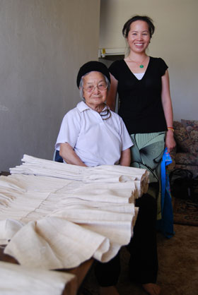 Master textile artist Ju Yang (left) and her daughter-in-law and 2008 apprentice Pao Ge Vue, with the tiab dawb that was completed as part of their apprenticeship.